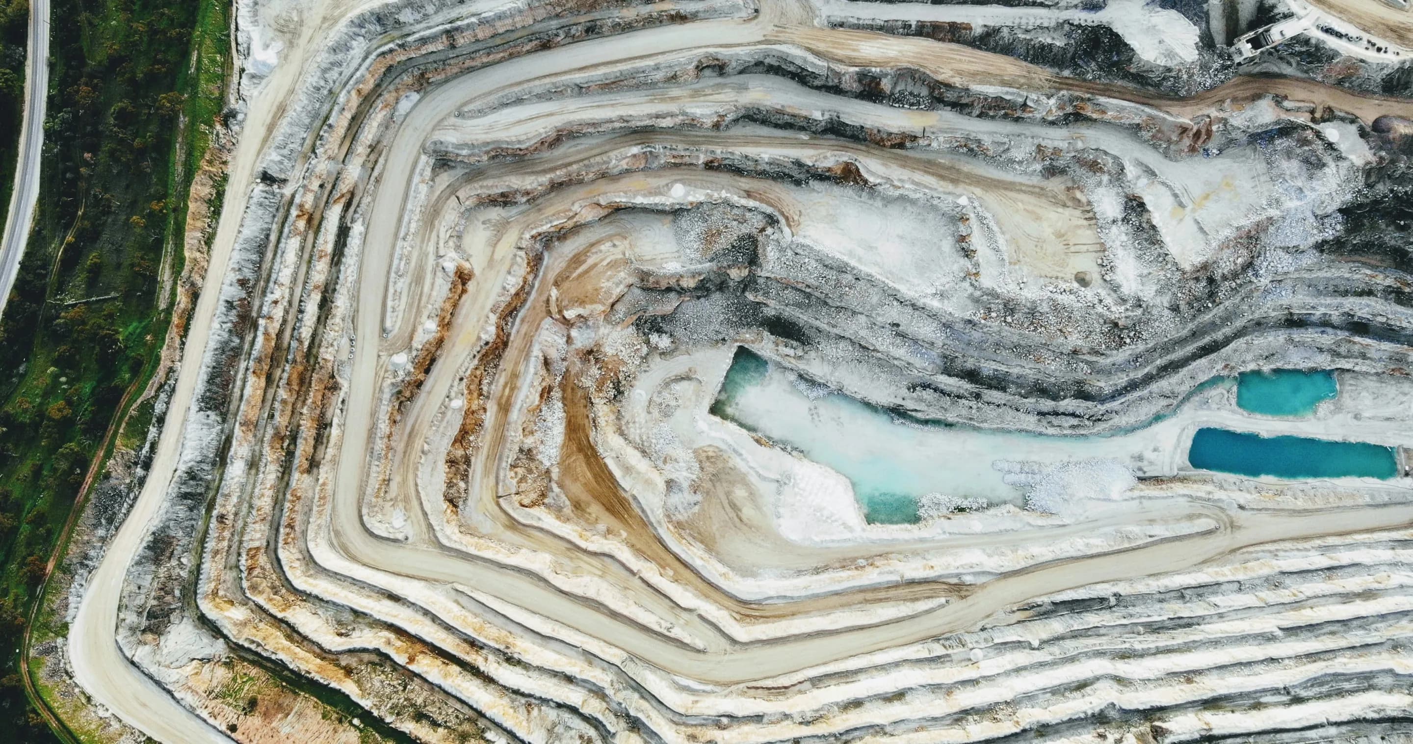 Aerial view of the terraced roads and working surfaces of an open-pit mine.